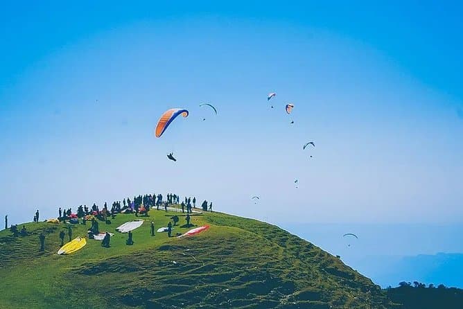 Paragliders over the green Bir Billing valley in Kangra, Himachal Pradesh